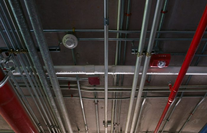 Sanitary system pipes and electrical cables installed under flat slab reinforced concrete structure in building.Ventilation pipes in Underground Parking