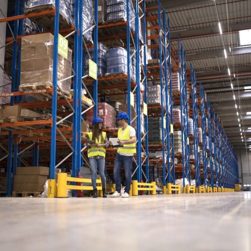 Warehouse workers discussing about logistics and distribution packages to the market.